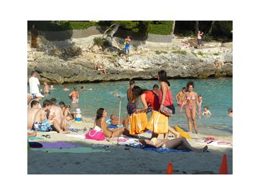 Els joves del Camp de treball de Teatre que es fa a Calonge repartiren 150 borses amb fruita fresca a la platja de Cala d’Or