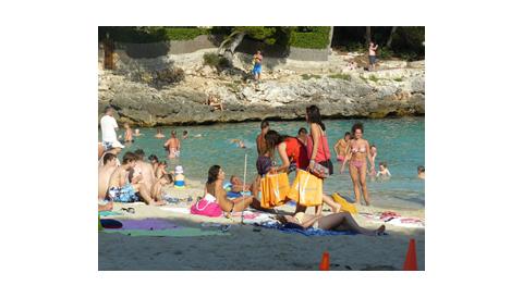 Els joves del Camp de treball de Teatre que es fa a Calonge repartiren 150 borses amb fruita fresca a la platja de Cala d’Or